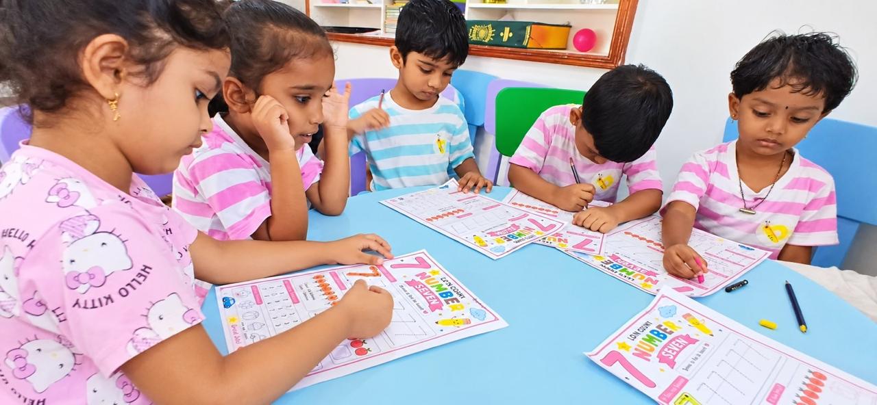 Kinderbee children tracing numbers on worksheets